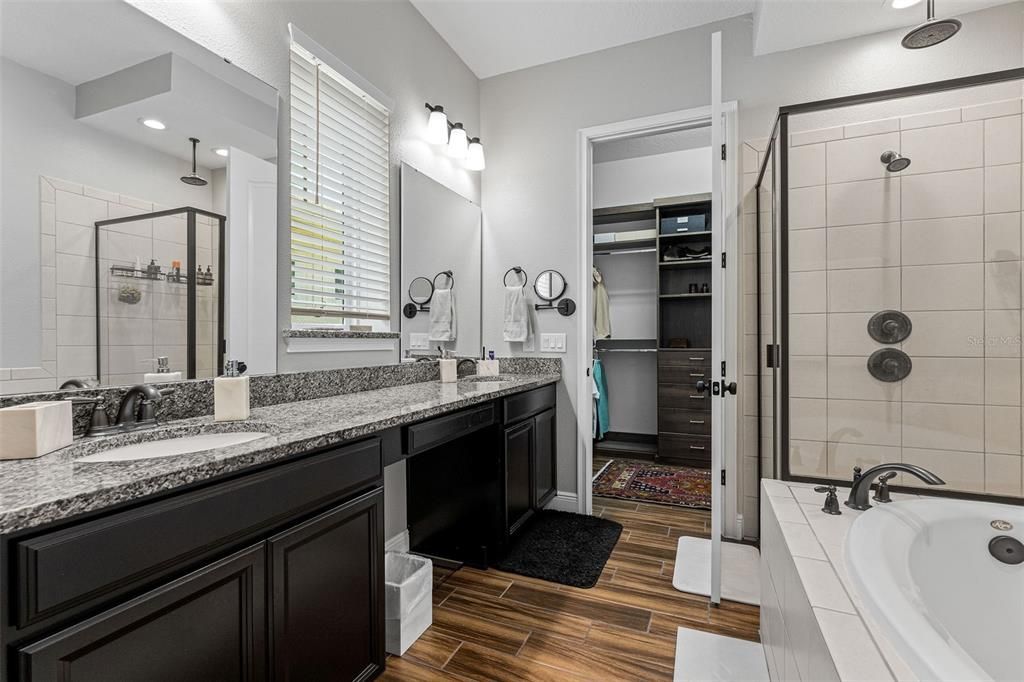 Primary bathroom with double vanity, makeup counter and walk-in closet.