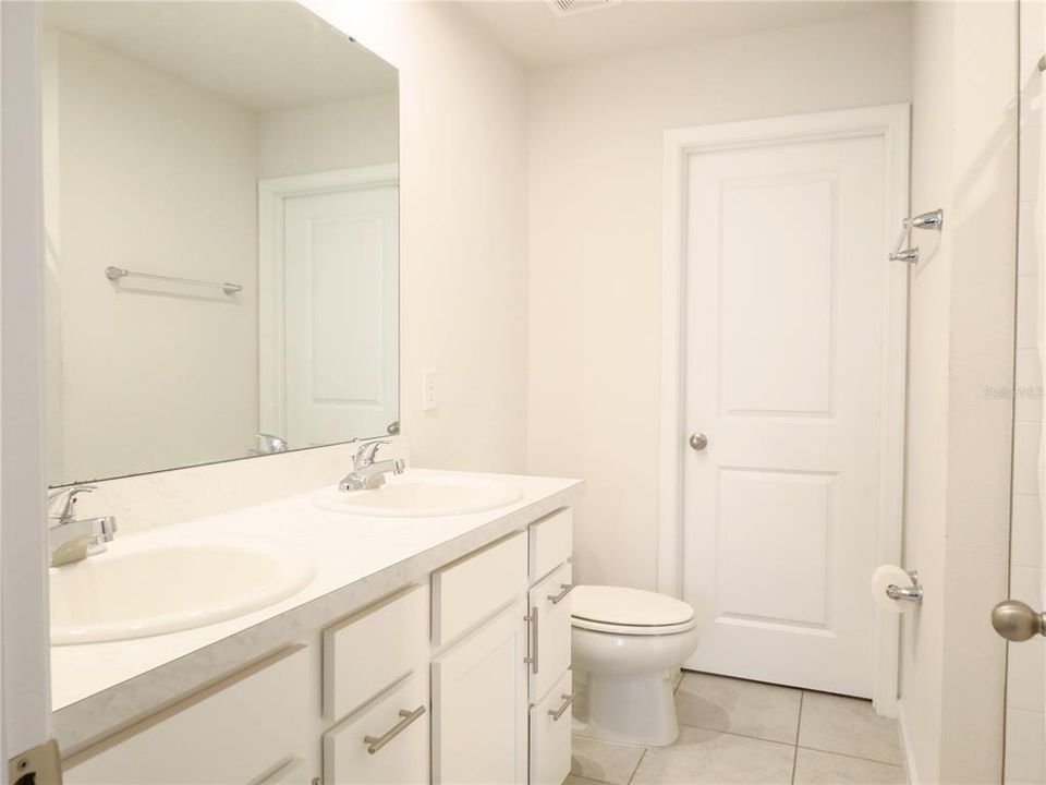 Main Bathroom has double sinks and tiled floors