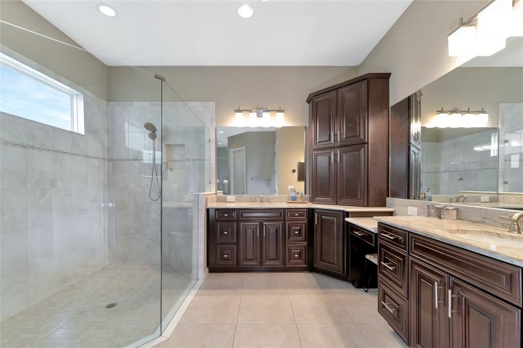 Walk-in shower, ample cabinets & drawers, dressing table, & granite vanity tops.