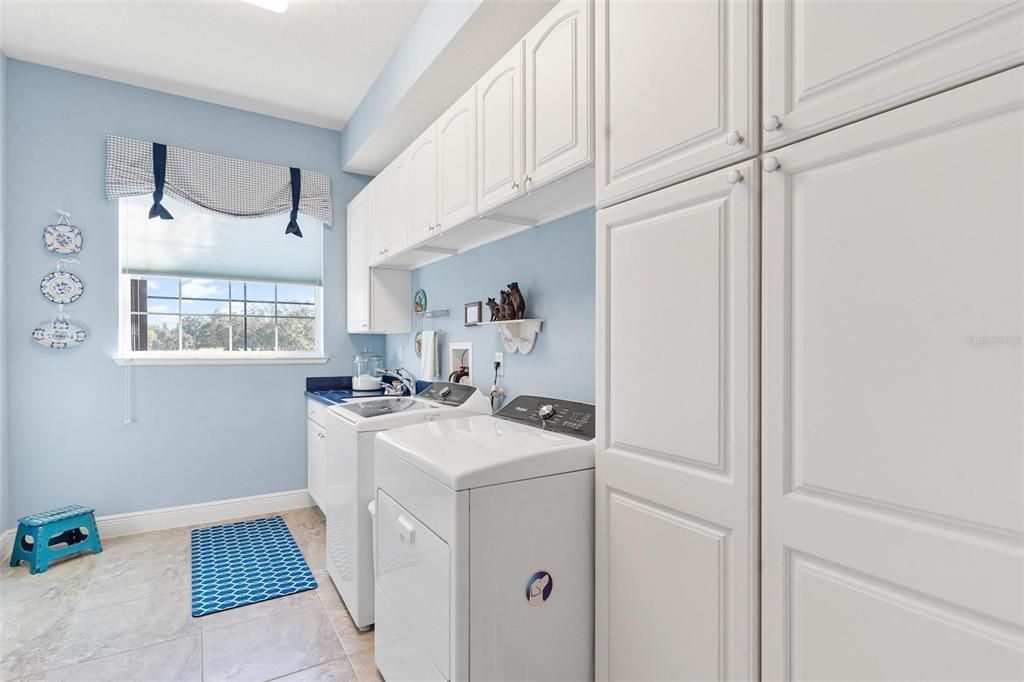 Laundry Room with Custom Cabinets, Utility Sink, and Whirlpool Washer and Dryer