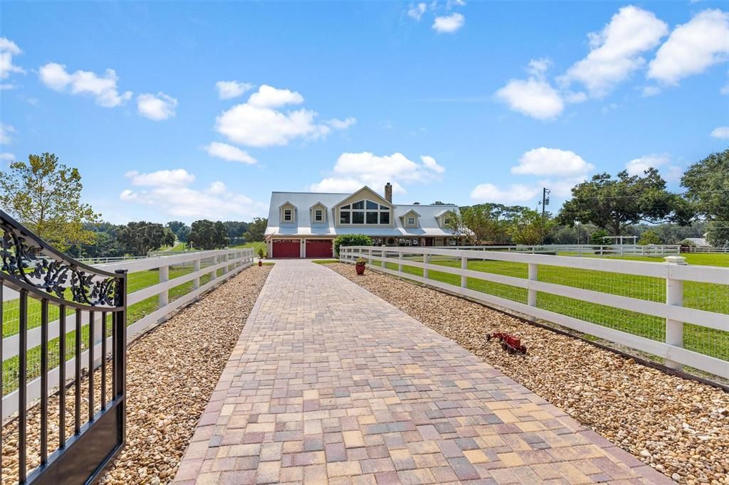 Private Entry through Iron Gate Entrance into Estate on long Brick Paver Driveway