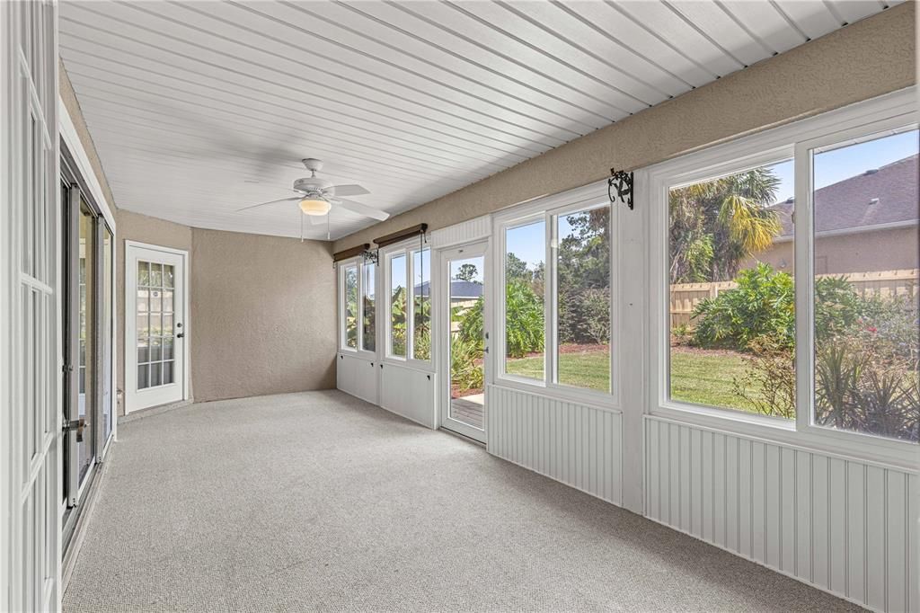 Enclosed porch with ceiling fan and expansive windows