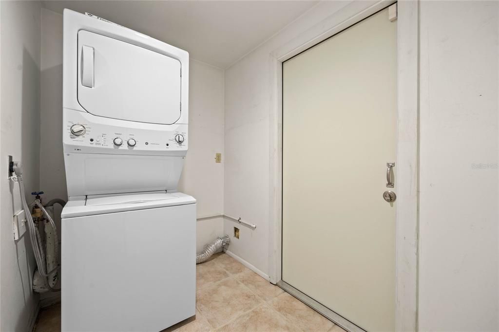 Laundry room with door to carport