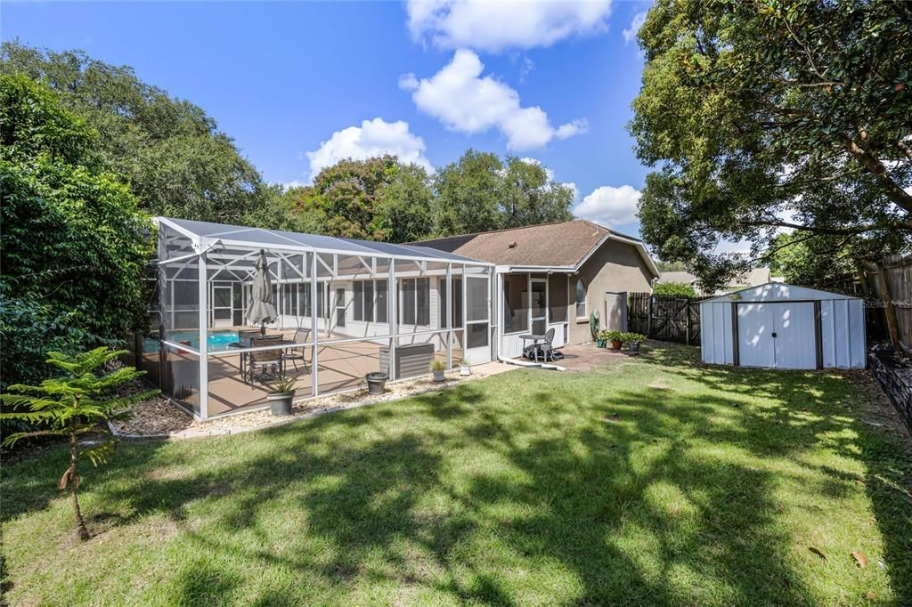 Back yard and screened in pool, the deck stretches across the entire back of house