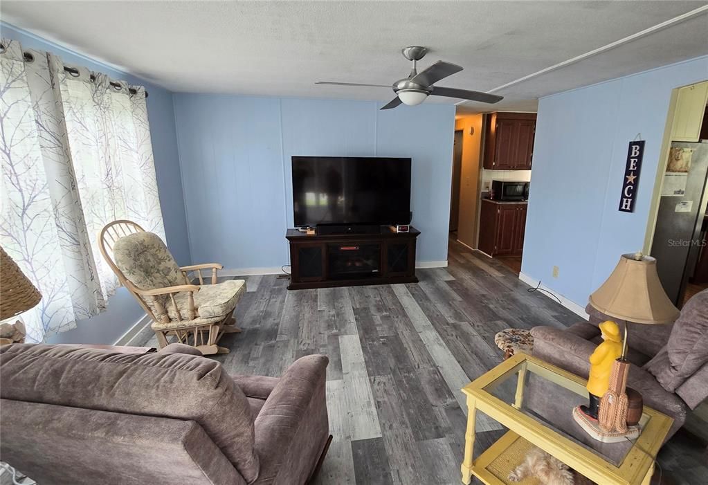 Watch TV and talk with friends in your living room. Note the hallway to the left of the TV that leads to the bedrooms and bathrooms.