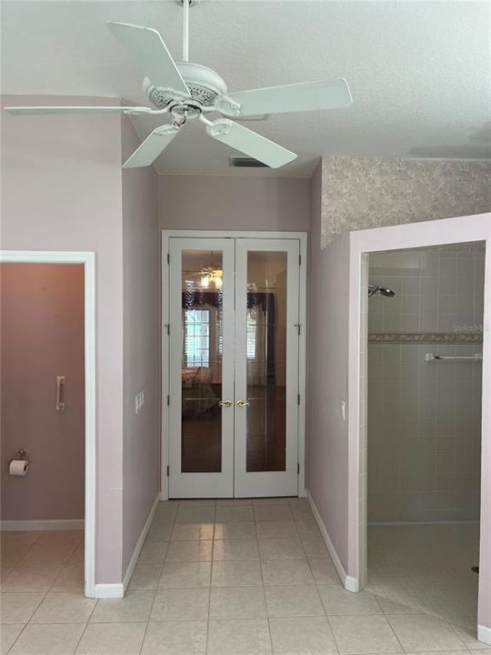 VIEW FROM BATHROOM FRENCH DOORS TO PRIMARY BEDROOM