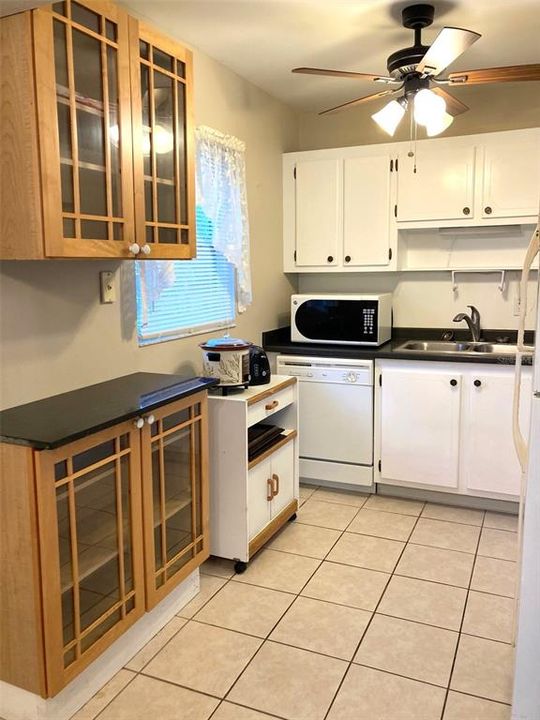 Galley style kitchen features a glass front cabinet/counter area.