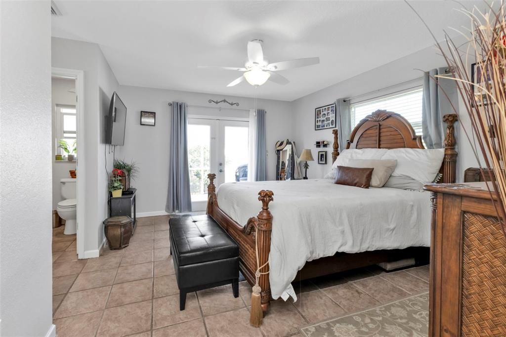 Master bedroom with walk in closet and French doors leading to lanai and pool.