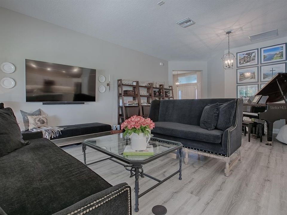 SPACIOUS LIVING ROOM WITH WALL MOUNTED TV THAT DOES REMAIN WITH THE HOME.