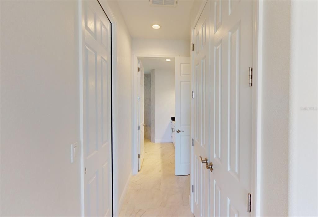 View from Primary bedroom into bath with double closets