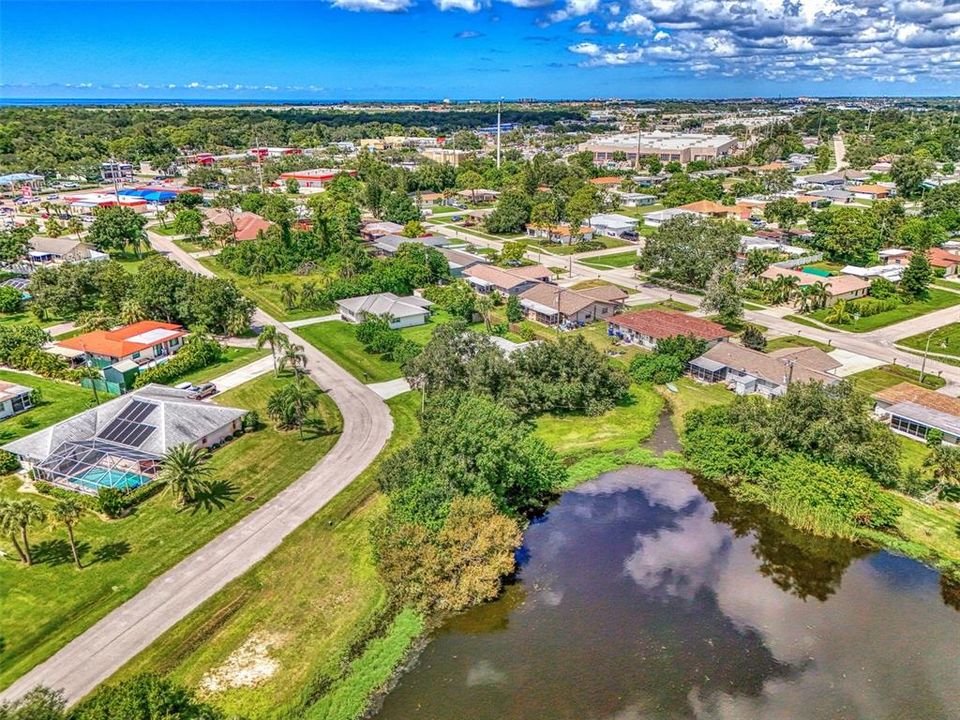 HOUSE BEHIND TREES OVERLOOKS POND