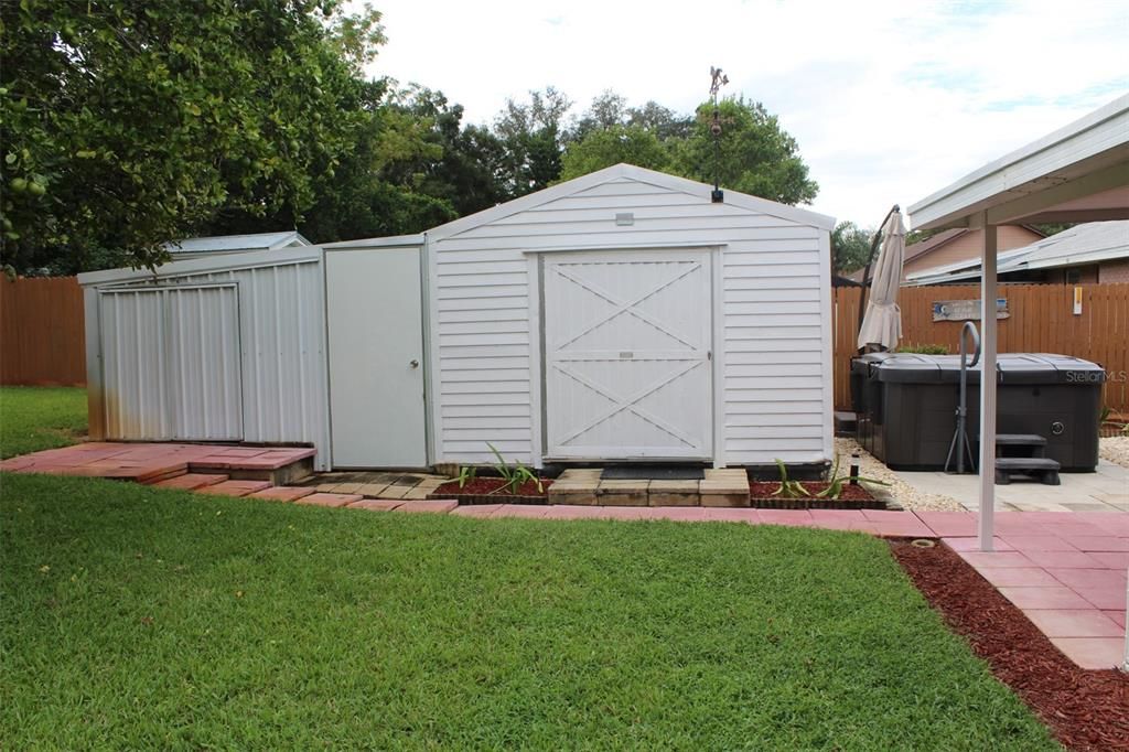 The storage shed on the left has a ridnig John Deere lawn mower.