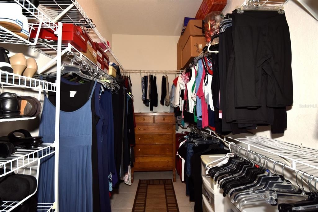 The primary bedroom walk-in closet has ample shelving.