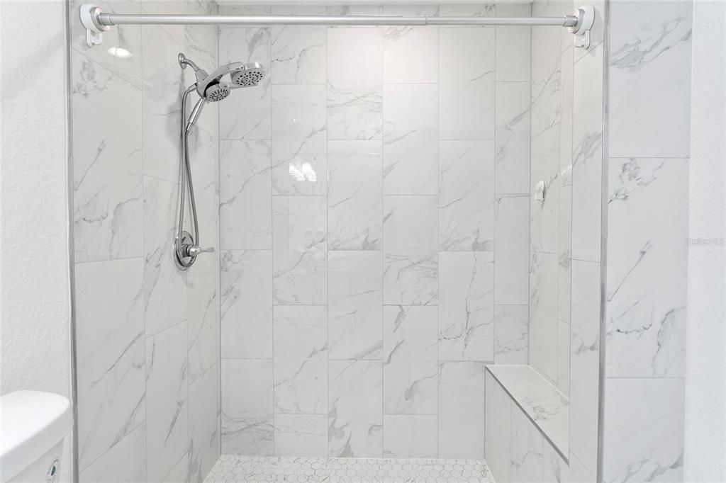 Shower with a bench in the primary  bathroom