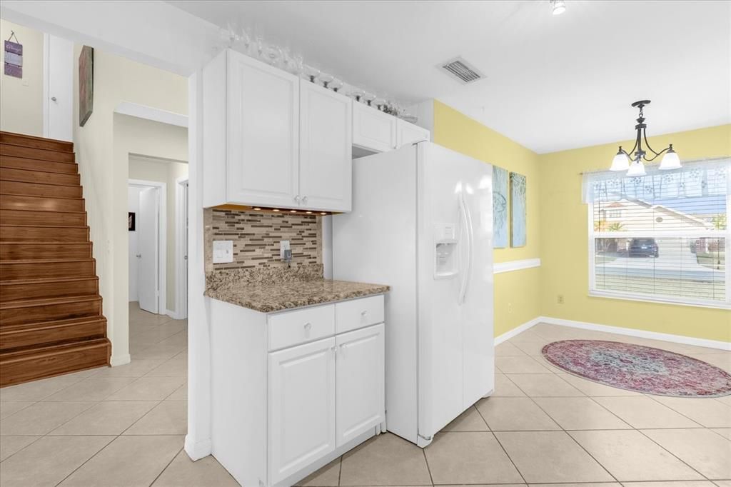 Spacious kitchen- White solid wood cabinets, White Appliances, Granite Counters, Glass Backsplash, LED lighting with breakfast nook