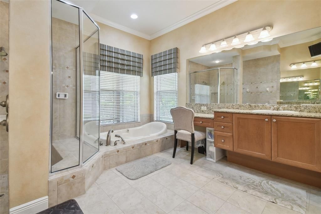 En suite bathroom with Jacuzzi tub, split vanity & walk-in shower.