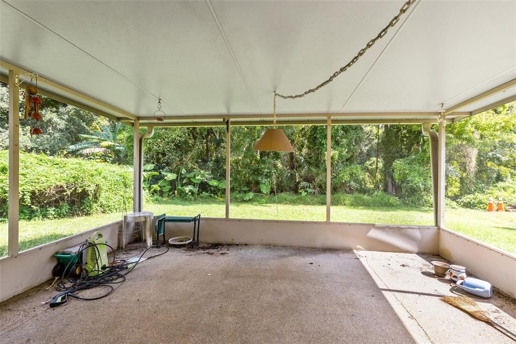 The screened lanai offers serene views of your private backyard.