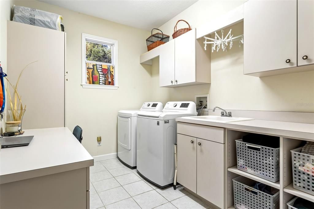 Spacious laundry room with built in desk as well as cubby storage