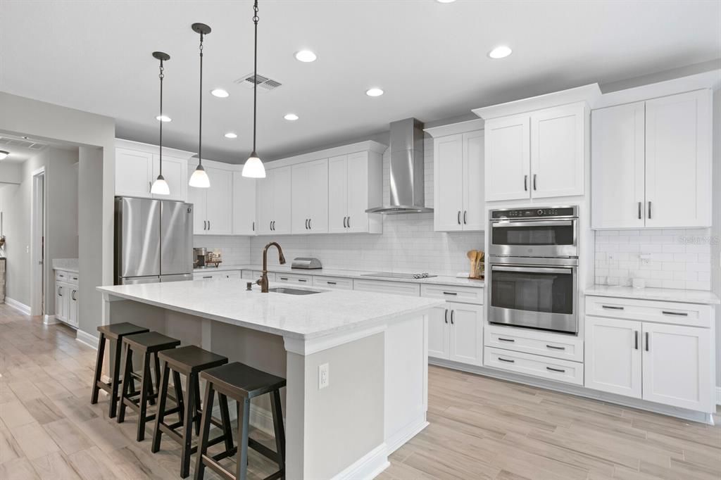 Kitchen is stunning in white with quartz countertops & stainless steel appliances.