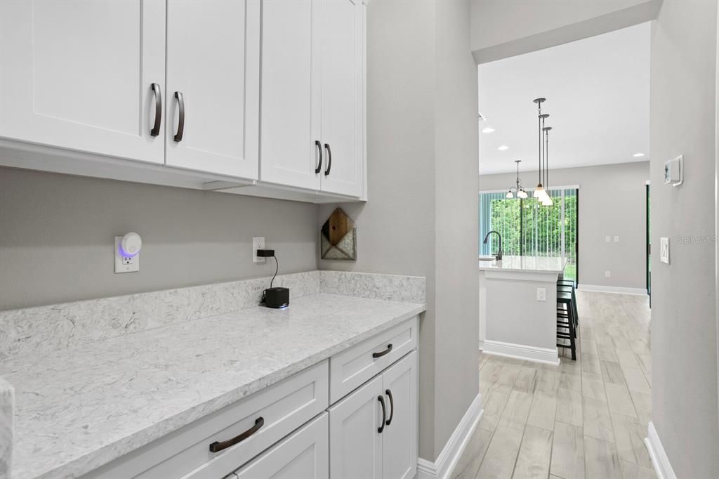 Butler's pantry with huge pantry closet perfect for additional storage, appliances, and prep area to the formal dining room.