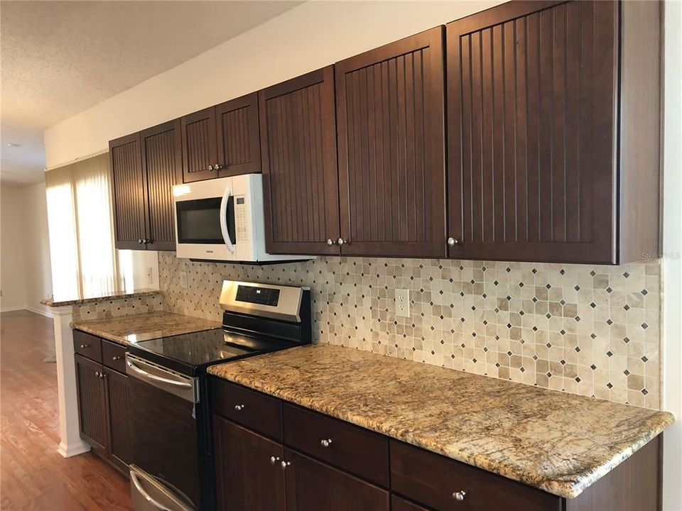 Kitchen has Upscale Cabinets and Stylish Backsplash.