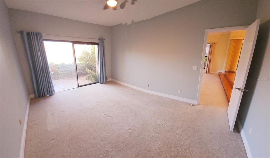 Primary bedroom.  Looking out sliding glass doors toward backyard sitting area and pond.