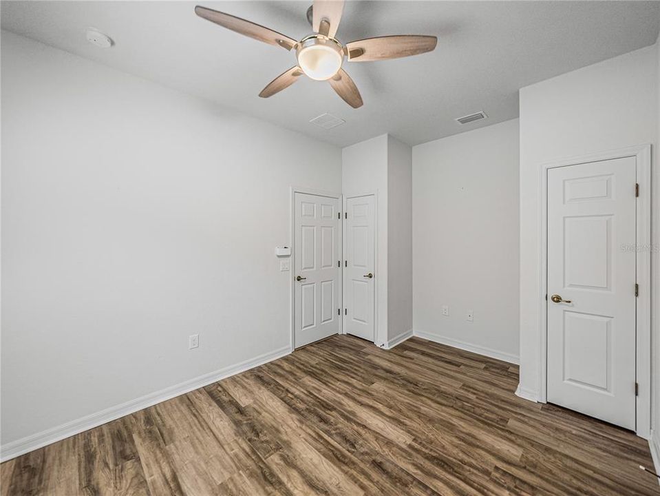 Dual closets in 3rd bedroom with desk area