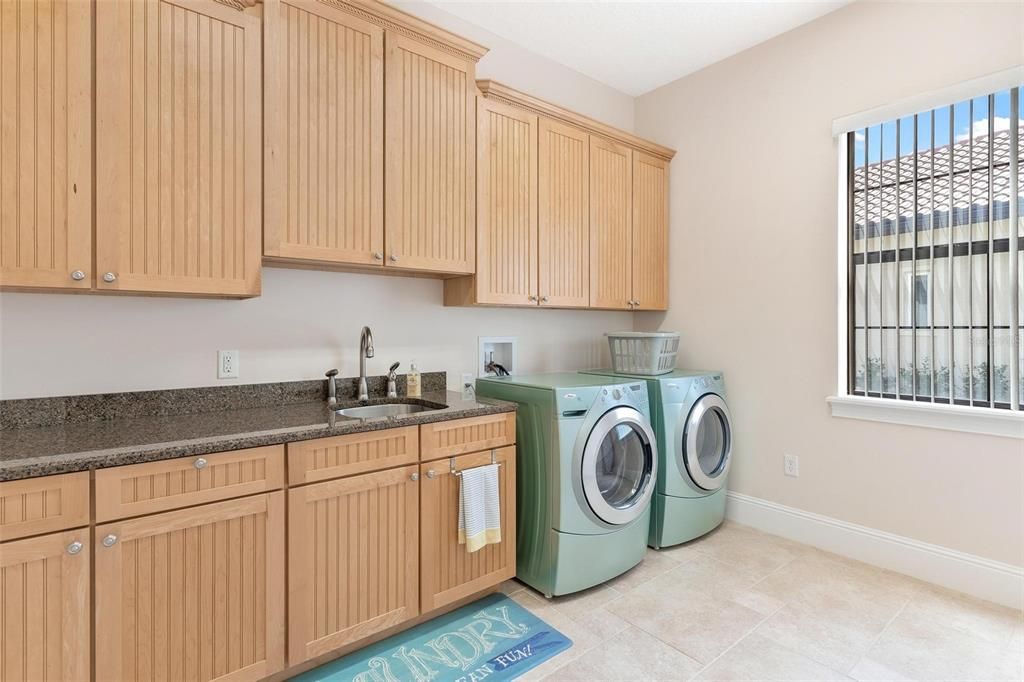 Laundry Area with a Granite Sink and Front Load Washer and Dryer which convey