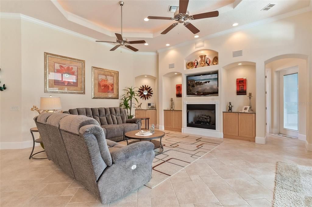 Living Area with Tray Ceilings, Built-in Shelving, and Fireplace