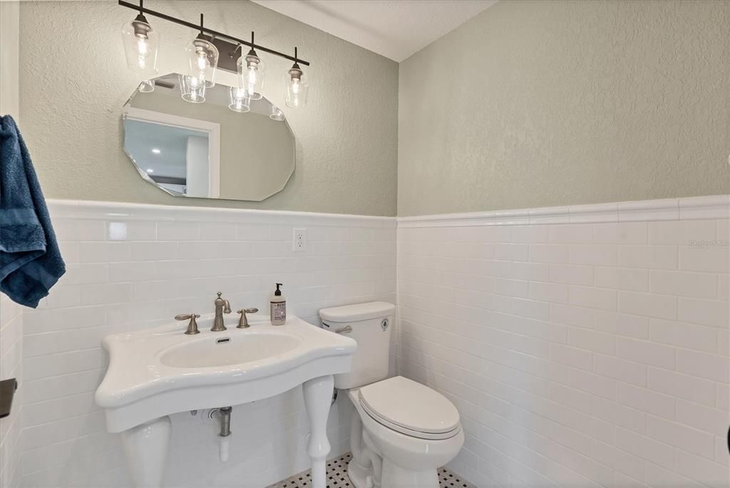 Elegant tile, new fixtures, and a porcelain sink grace the powder room.