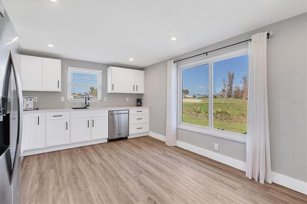 The updated kitchen feautures Shaker-style cabinetry, granite countertops, and a large window to feature a picturesque view of the golf course.