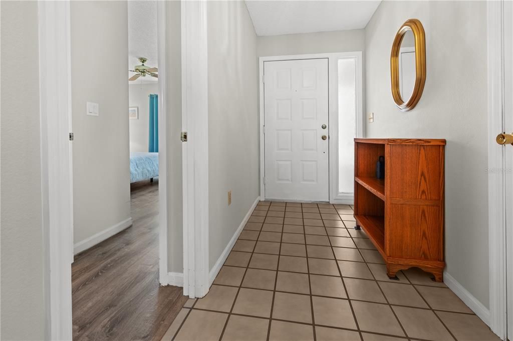 FOYER ENTRY HAS TILE FLOOR AND A COAT CLOSET FOR EXTRA STORAGE. THE DOORWAY TO THE LEFT IS THE 2ND BEDROOM AND BATHROOM.