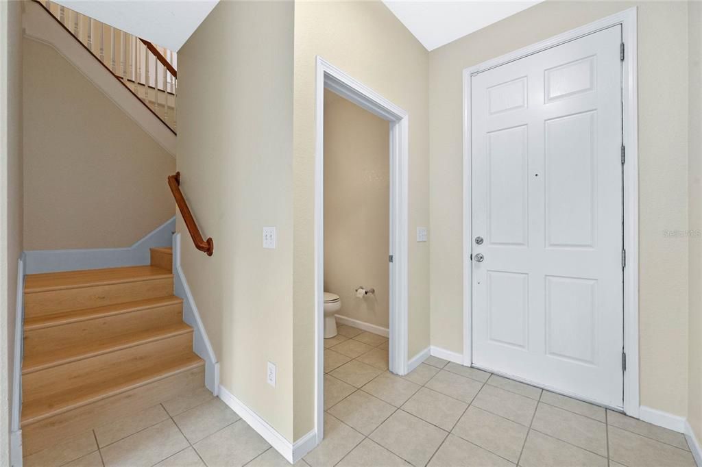 Foyer showing Front Door, Half Bathroom, and stairs