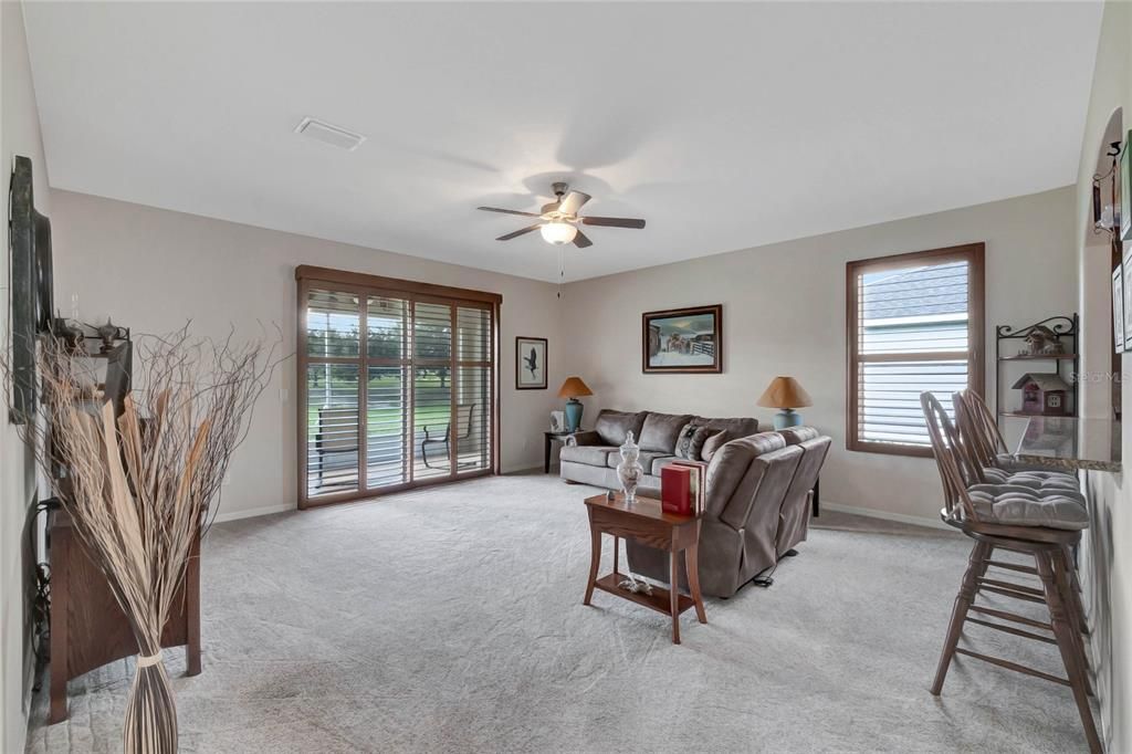 Great room with patio doors that lead to screened porch overlooking golf course.