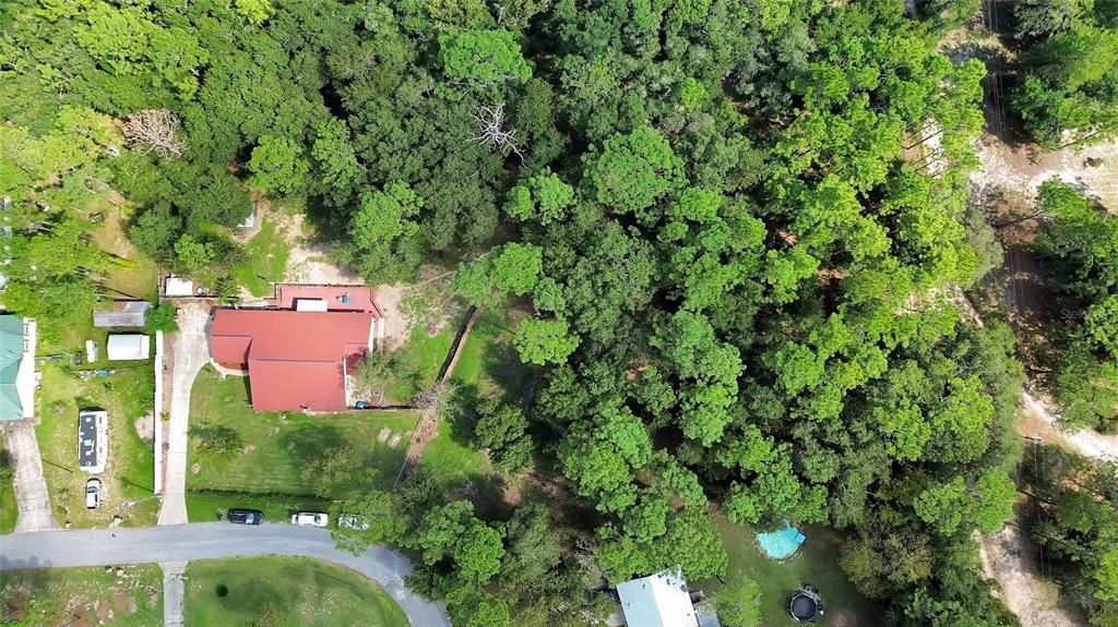 Ariel shot showing lot to the right of home/wooded