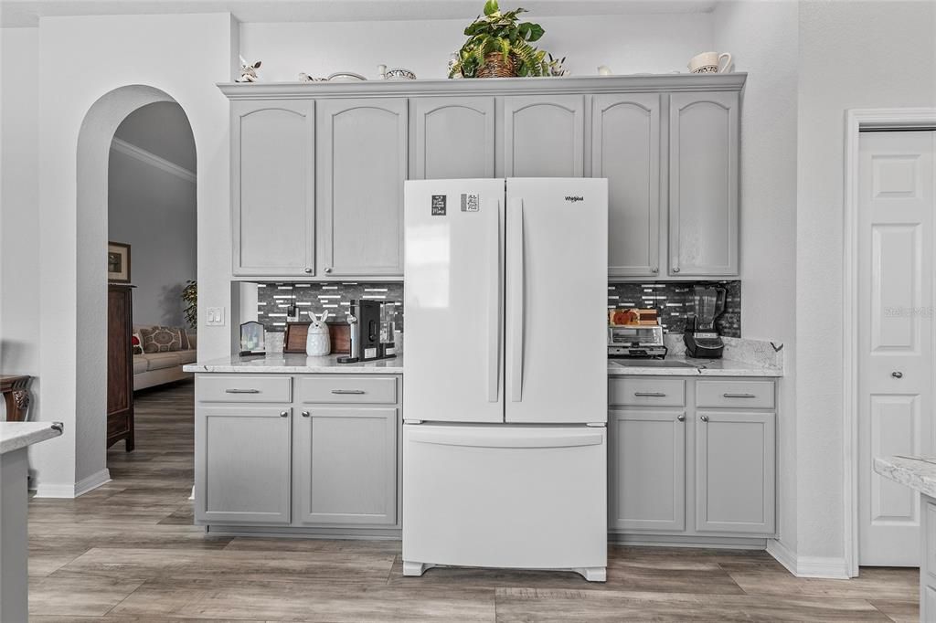 Kitchen with new refrigerator, Painted cabinets, Quartz counter tops, backsplash, door to right is pantry