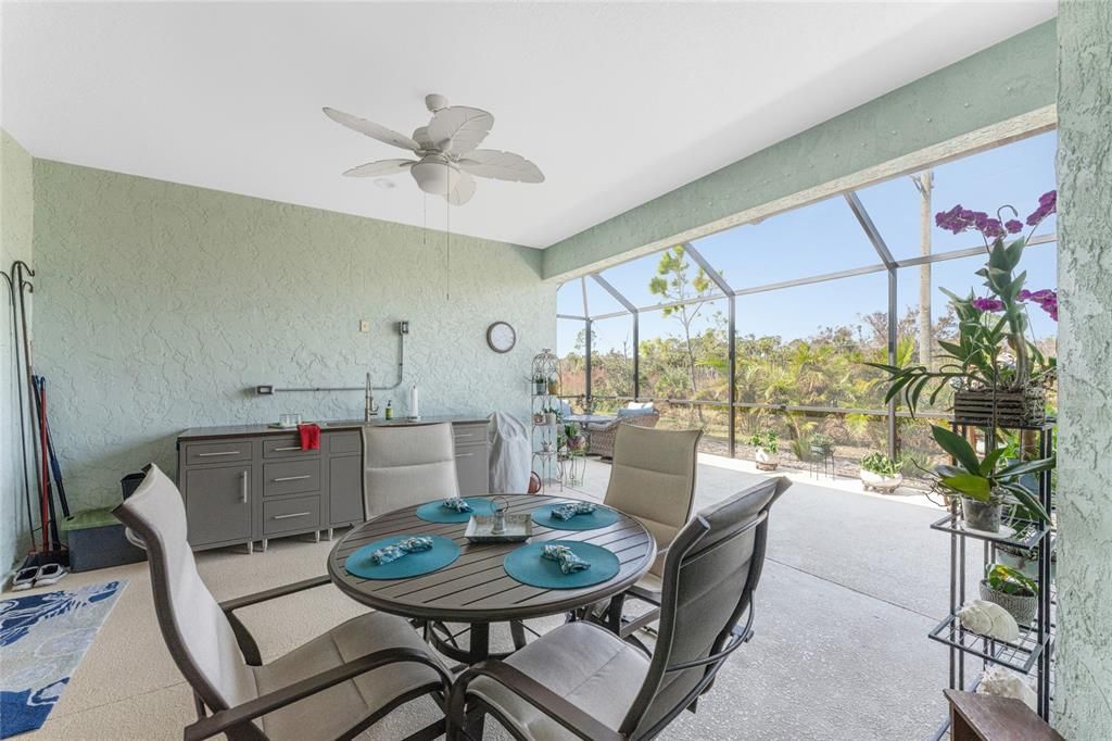 Outdoor dining area has ceiling fan with lighting