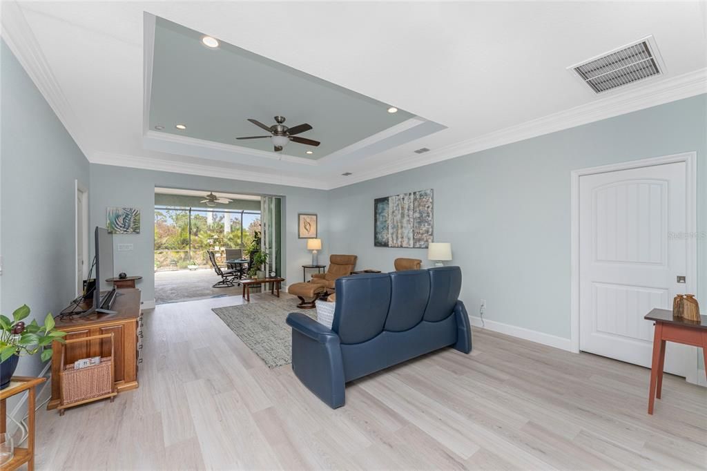 Living area has tray ceiling and a full-on nature view