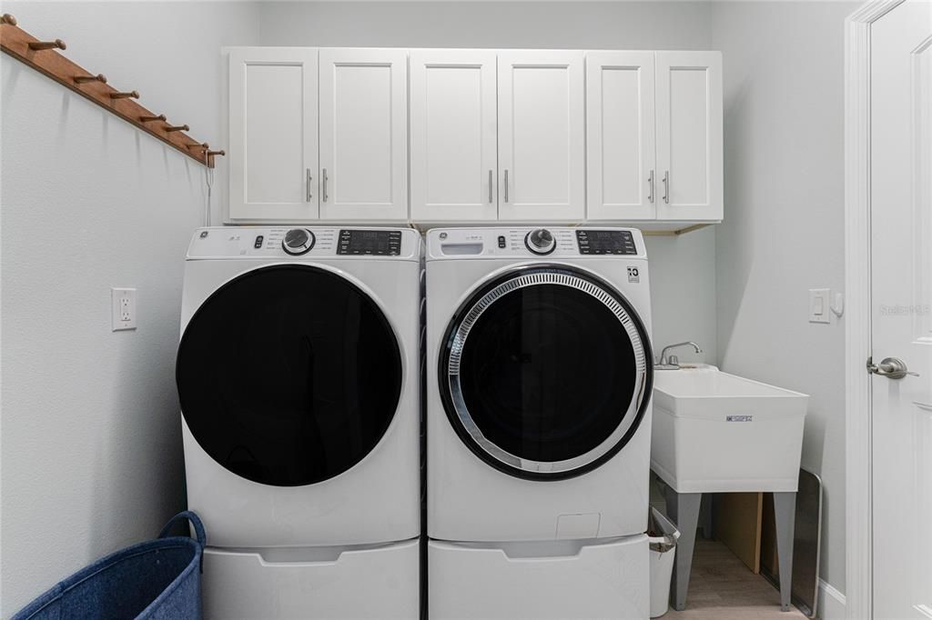 Laundry room is well appointed with soak tub and storage cabinets