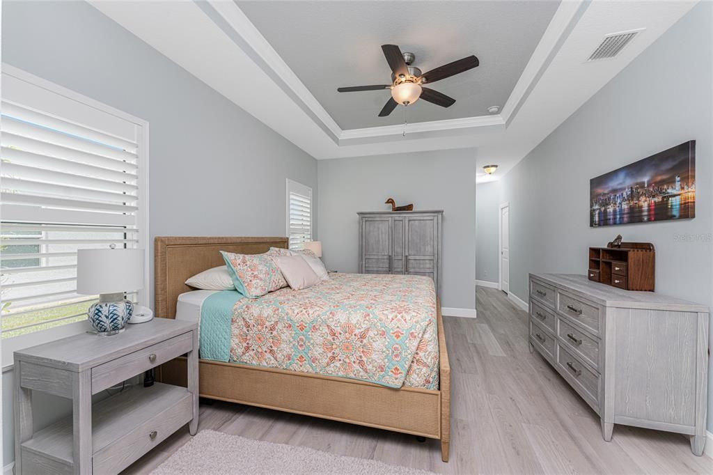 Primary bedroom has tray ceiling with crown molding