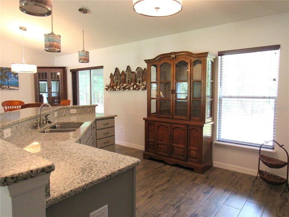 Kitchen Open To Great Room & Dining Area w/ Large Granite Serving Bar & Cathedral Ceiling.