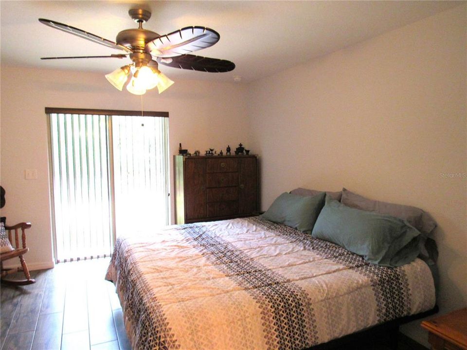 Lovely Owner's Suite With Porcelain Tile Floor and Glass Sliding Doors To The Beautiful Outdoors!