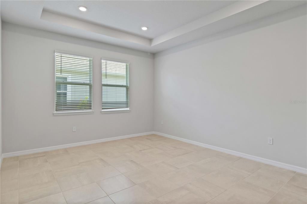 Mother-in-law wing of house with tile floors, tray ceiling, and bright windows.