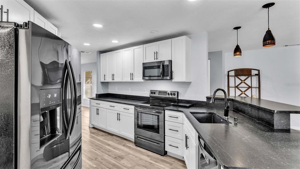 Kitchen view with White Shaker Cabinets, granite counters