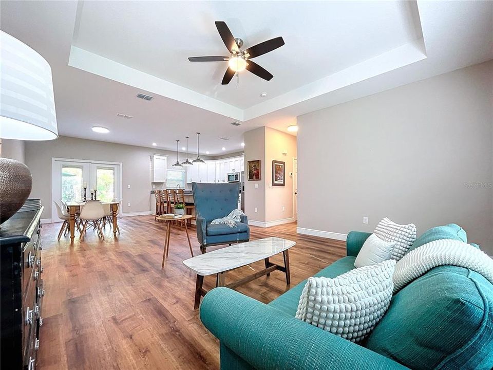 Welcoming and bright, the living room offers high tray ceilings and natural lighting.