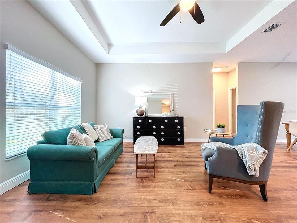 Welcoming and bright, the living room offers high tray ceilings and natural lighting.