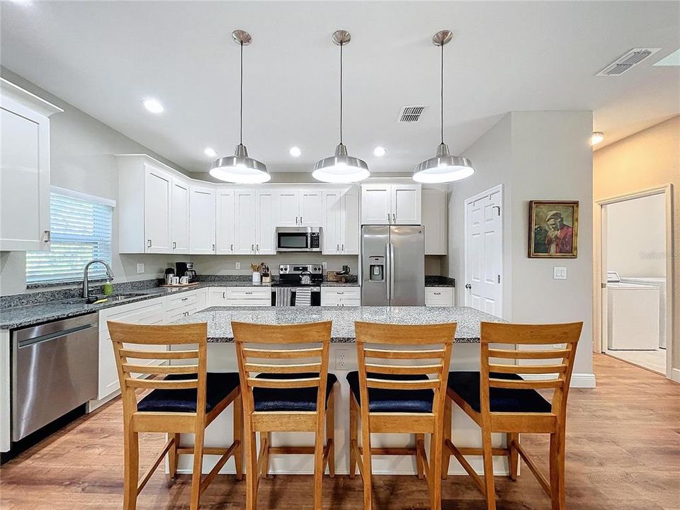 Large island with granite countertop offers a great space for entertaining.