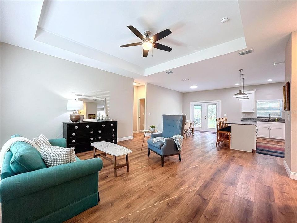 Welcoming and bright, the living room offers high tray ceilings and natural lighting.