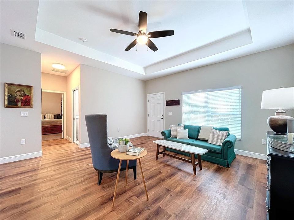 Welcoming and bright, the living room offers high tray ceilings and natural lighting.