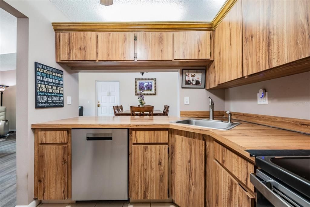 The kitchen is well-equipped with stainless steel appliances, a pantry, and plenty of cabinets and counterspace.